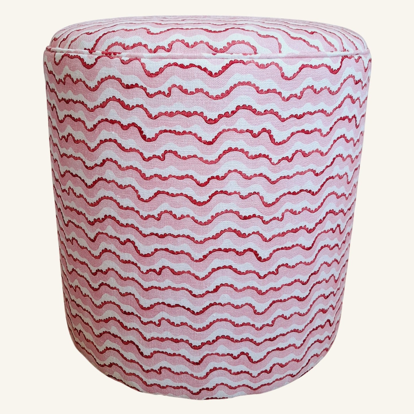 Round ottoman with red wavy pattern on a white background