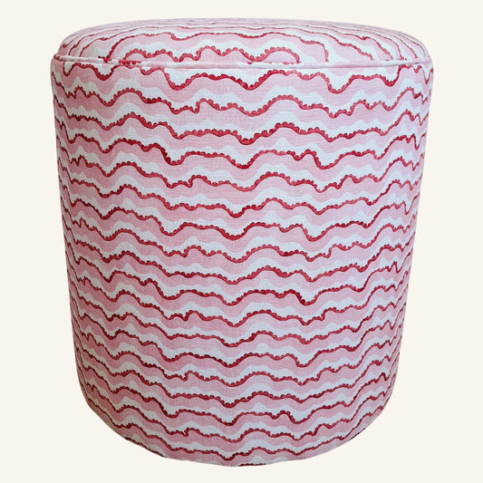 Round ottoman with red wavy pattern on a white background